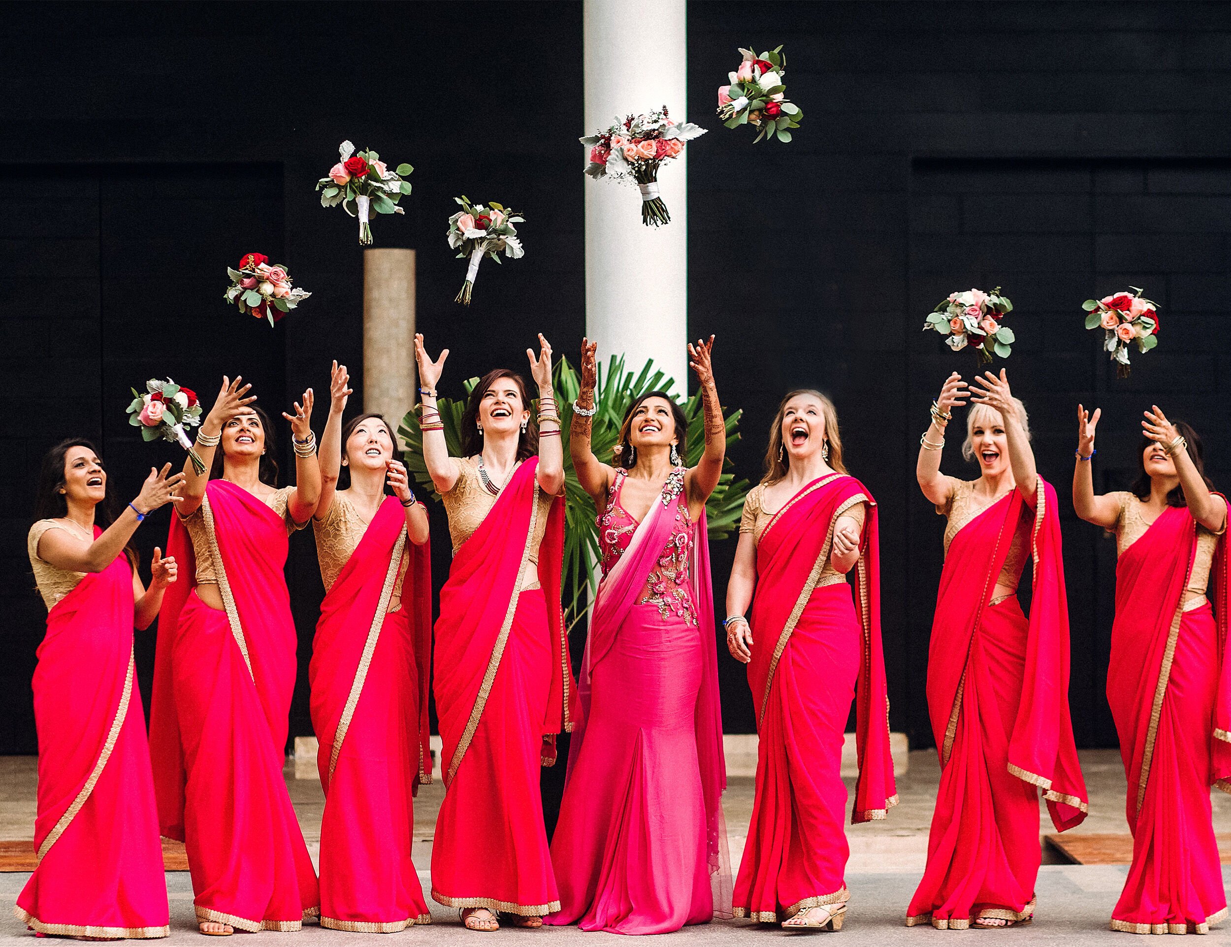 A bridesmaid in beautifull pink sarees throwing bouquet on wedding